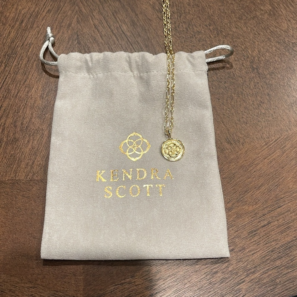 Kendra Scott gold colored necklace with emblem pendant
